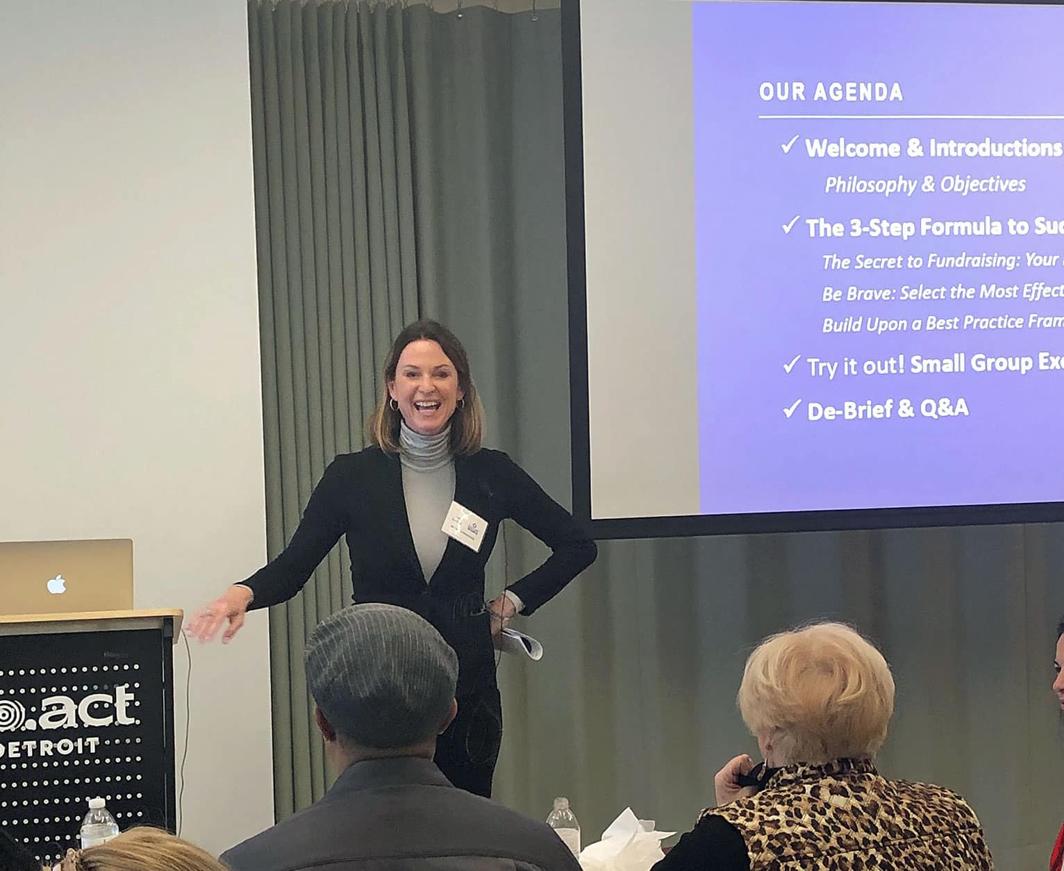 image of Aly Sterling standing infront of a presentation screen, teaching the CultureSource members in a workshop setting