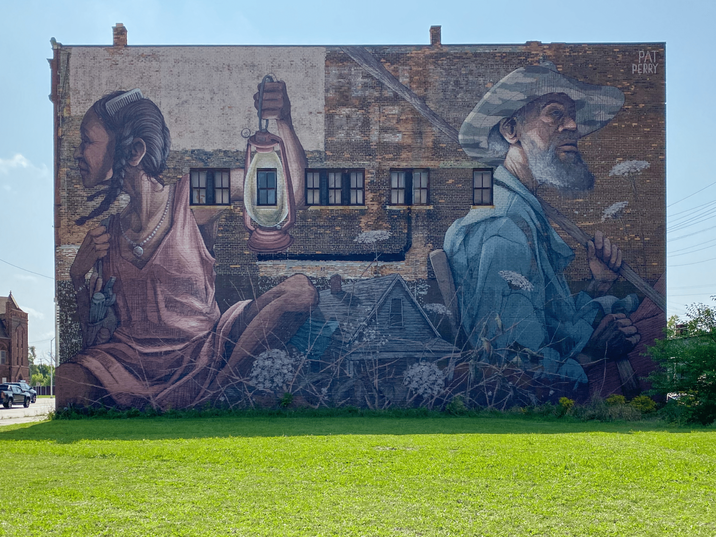 Photo mural on a wall with a young woman holding a lantern and an older man holding a shovel